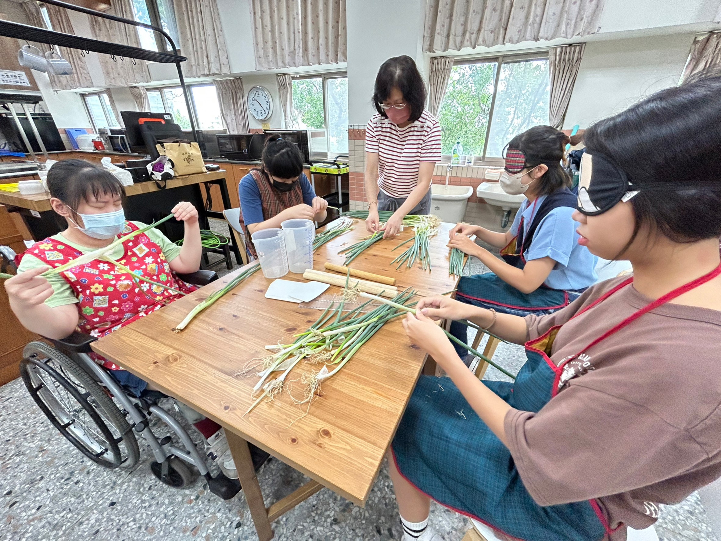 圖為亞大商品系同學,在惠明盲校體驗戴眼罩做蔥餅。