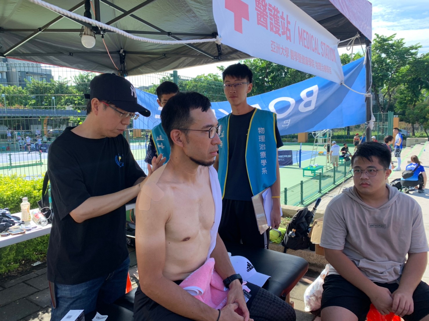 圖為亞大物治系陳彥年老師(左),帶領同學為選手進行運動傷害評估。