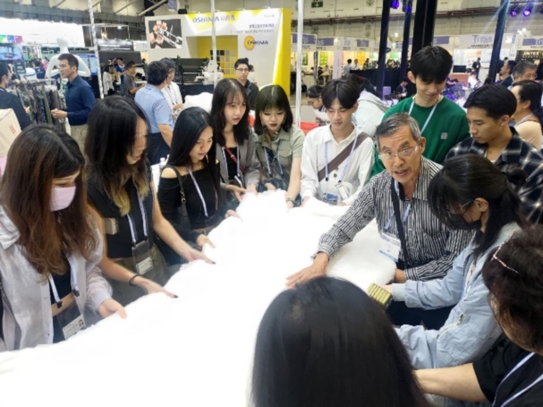 圖為在台北紡織展中,業者代表為亞大時尚系同學介紹新材料。