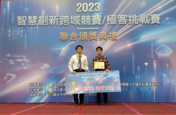 圖為亞大資工系同學蔡佳勳(右),代表團隊上台領獎。