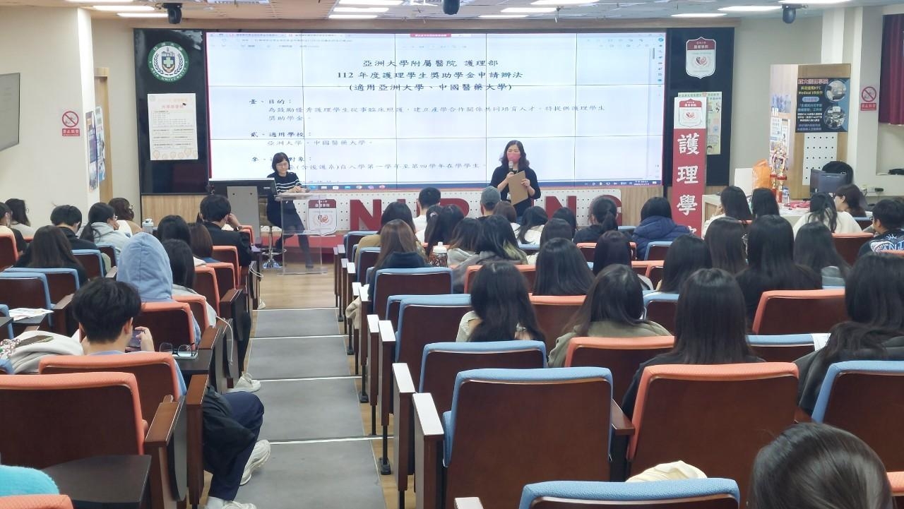 圖為亞大附醫護理部副主任莊錦娥(站立者),解說「亞大附醫在學獎助學金」細節。