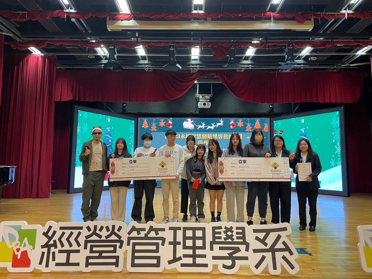 圖為亞大經管系參加黑客松競賽得獎同學,上台接受表揚。