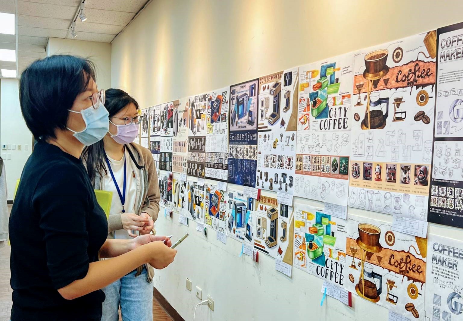 圖為亞大商設系黃雅毓老師,針對同學表現技法作品進行評審。