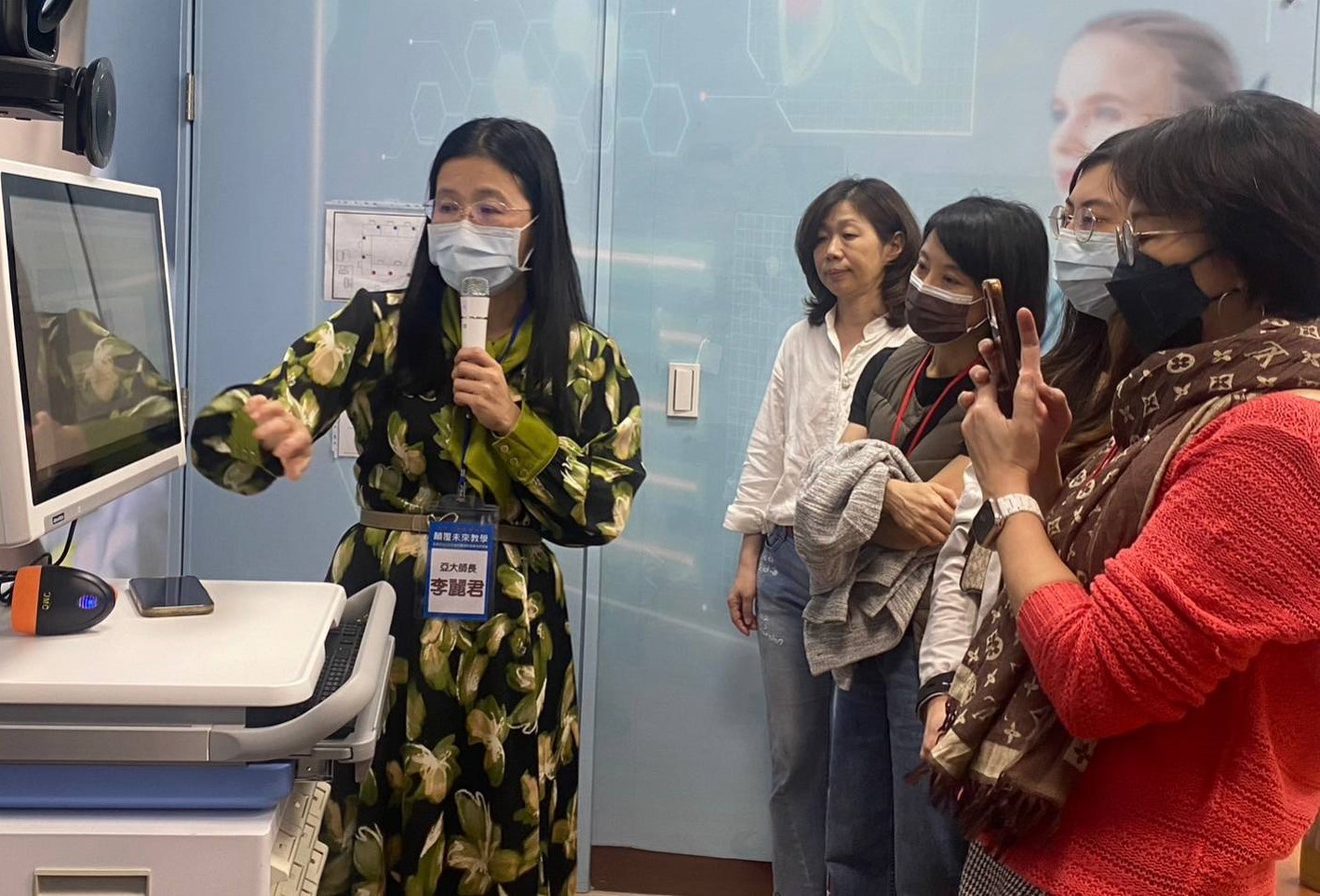 圖為參加實體場研討會學員,在亞大護理學院未來護理中心,體驗生成式AI虛擬人在身體評估課程的運用。