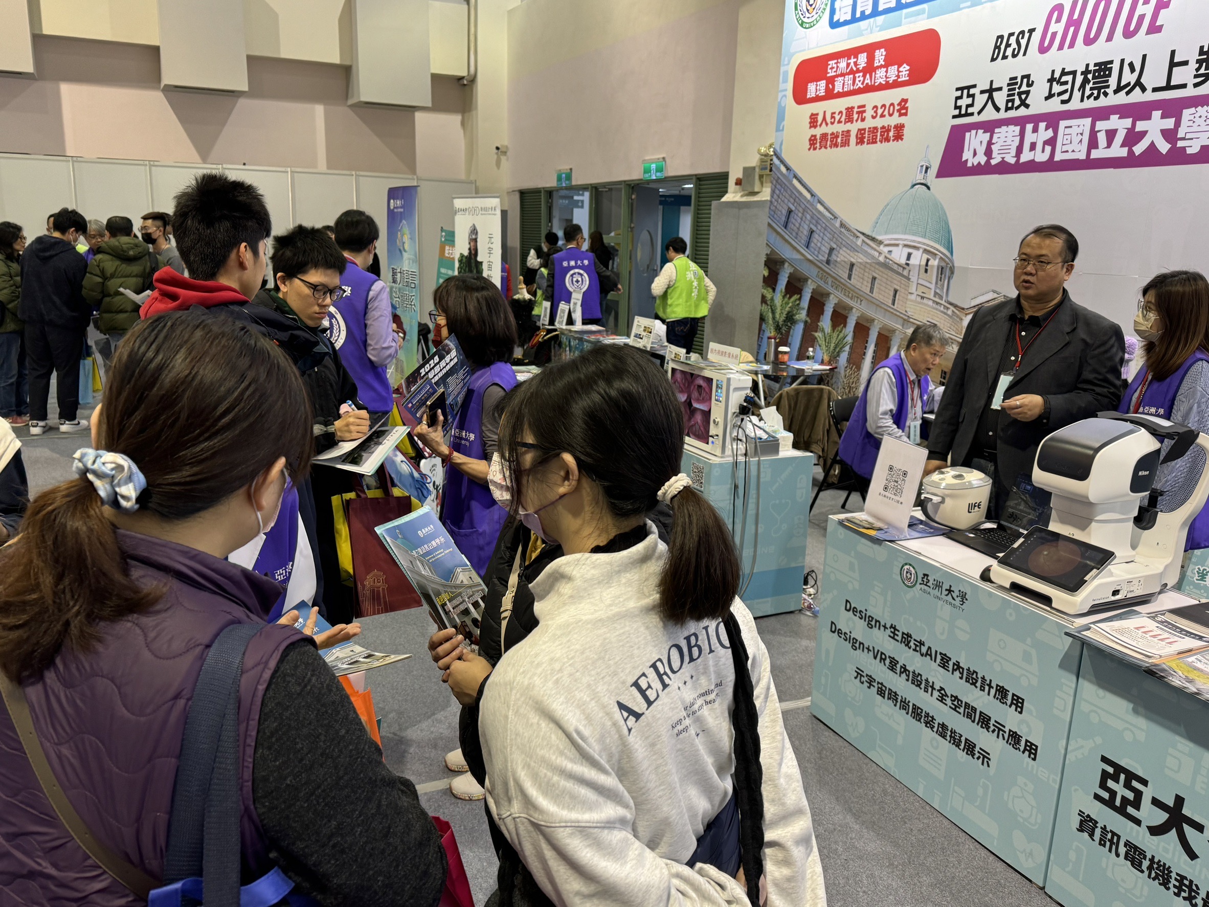 2024大學博覽會台北場,亞大攤位擠滿考生,仔細詢問有興趣就讀科系及獎學金。