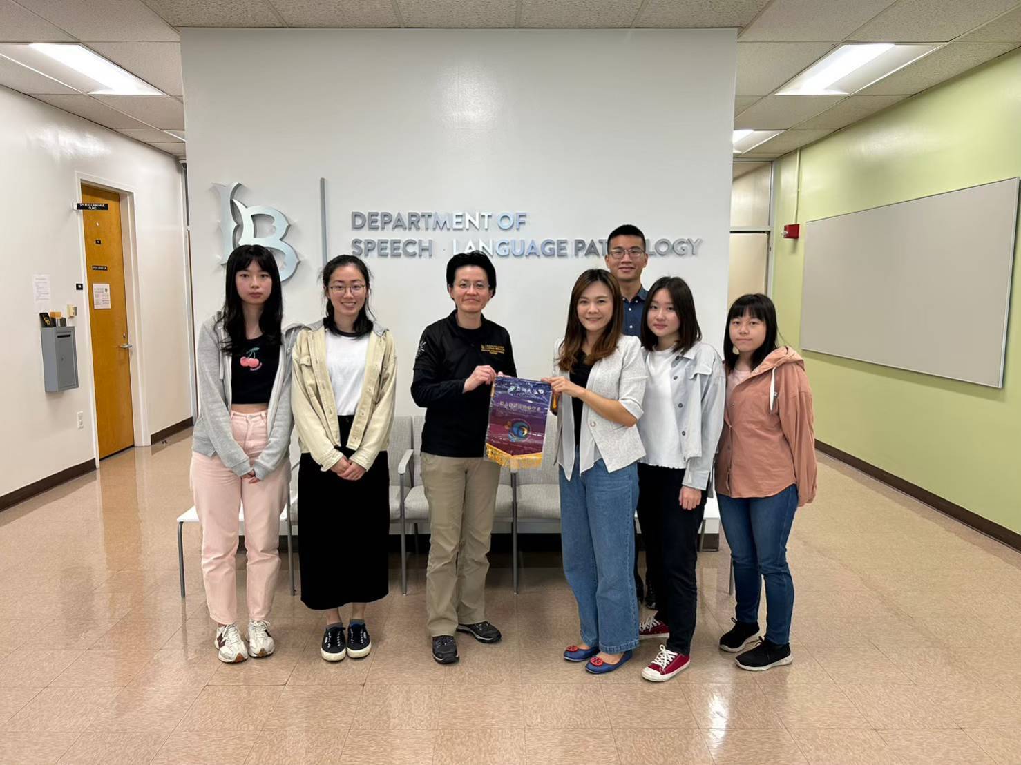圖為亞大聽語系王玉賢老師(左4),致贈感謝狀給美國加州大學長灘分校語言病理系主任洪佩芳主任(左3)。