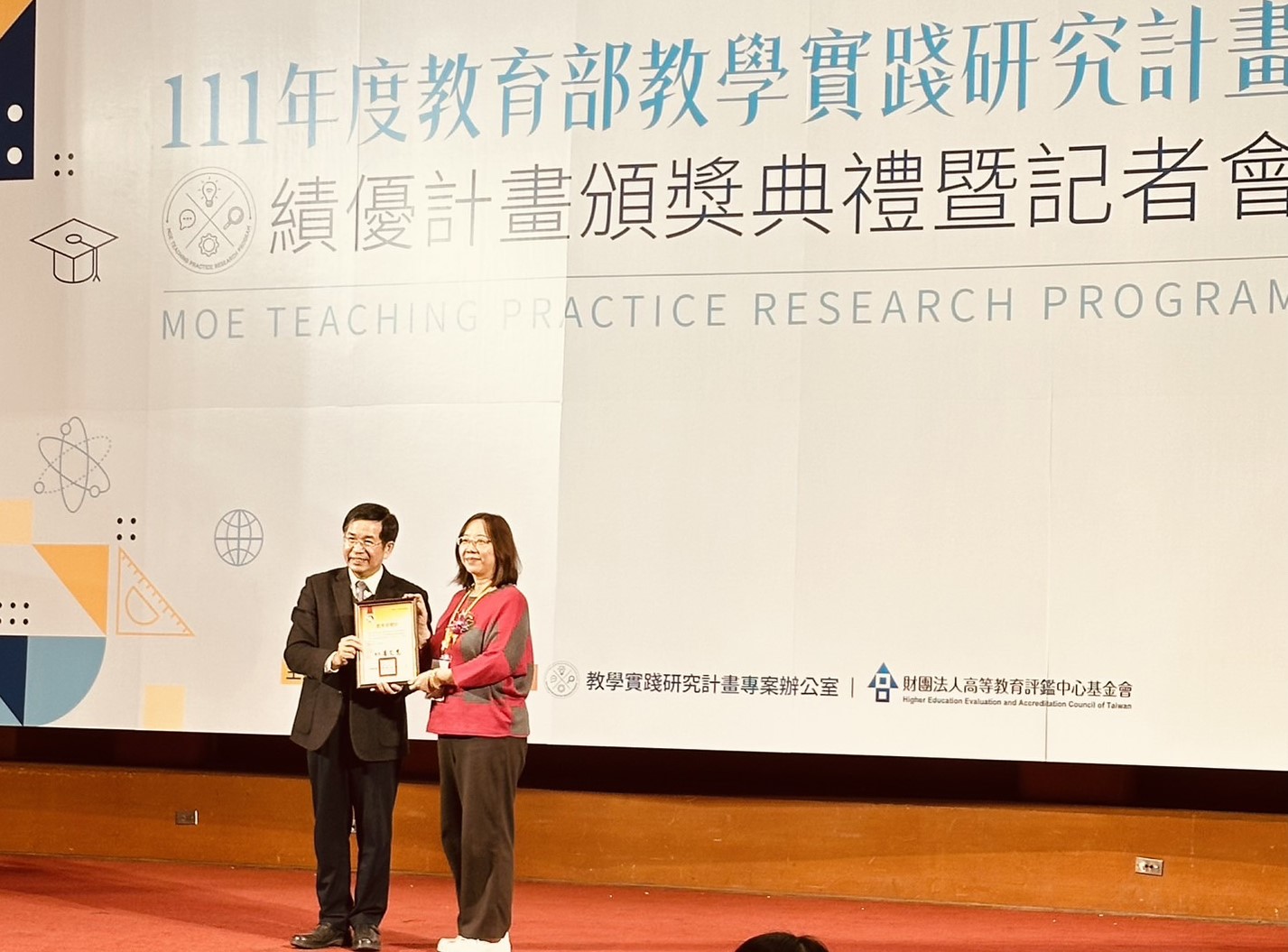 圖為教育部長潘文忠(左),頒獎給亞大休憩系童秋霞老師。