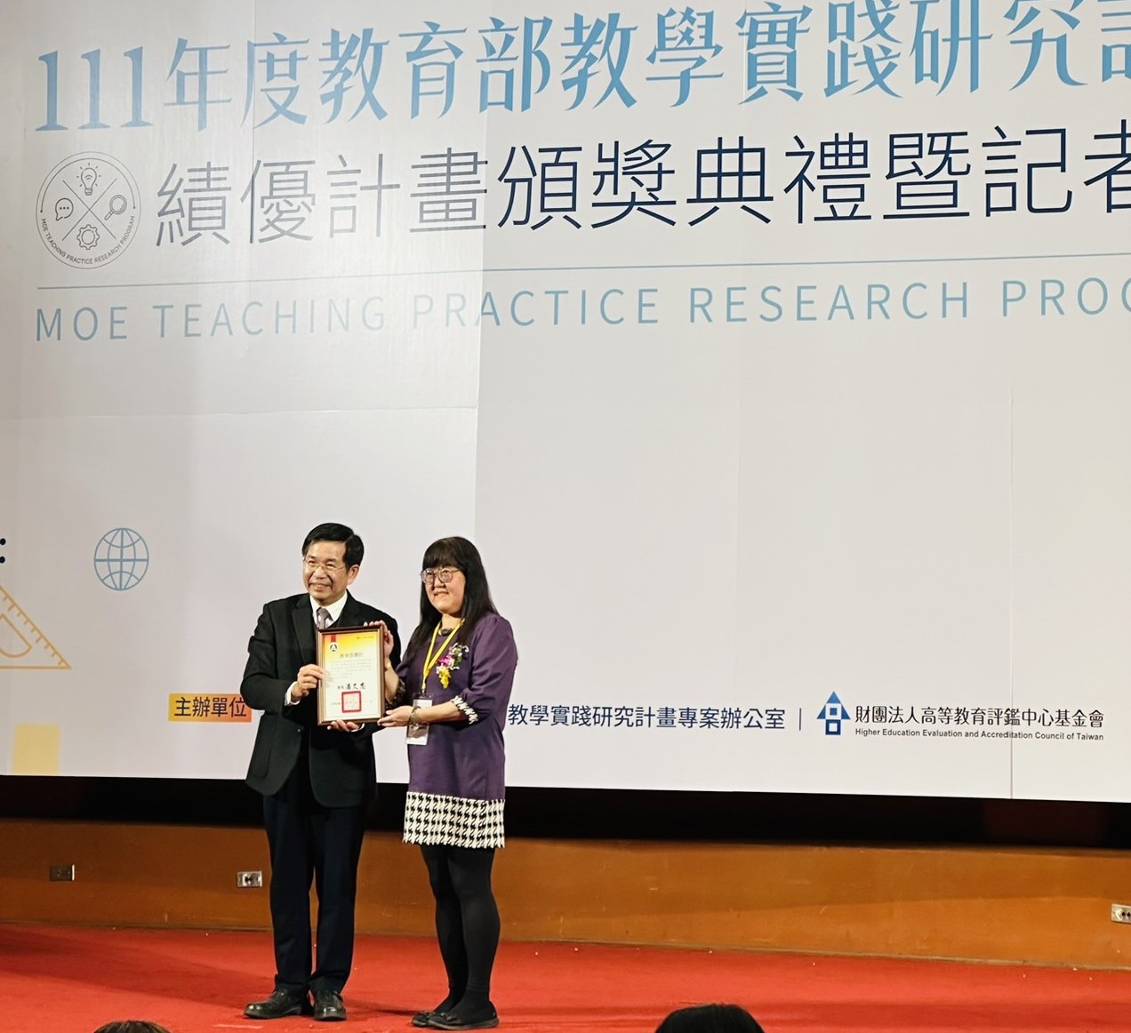 圖為教育部長潘文忠(左),頒獎給亞大護理學系靖永潔老師。