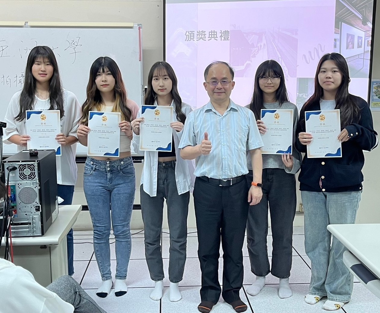 圖為亞大校園短影音競賽,資傳系主任陳士農(右3),頒獎給第1名的竹山高中團隊。