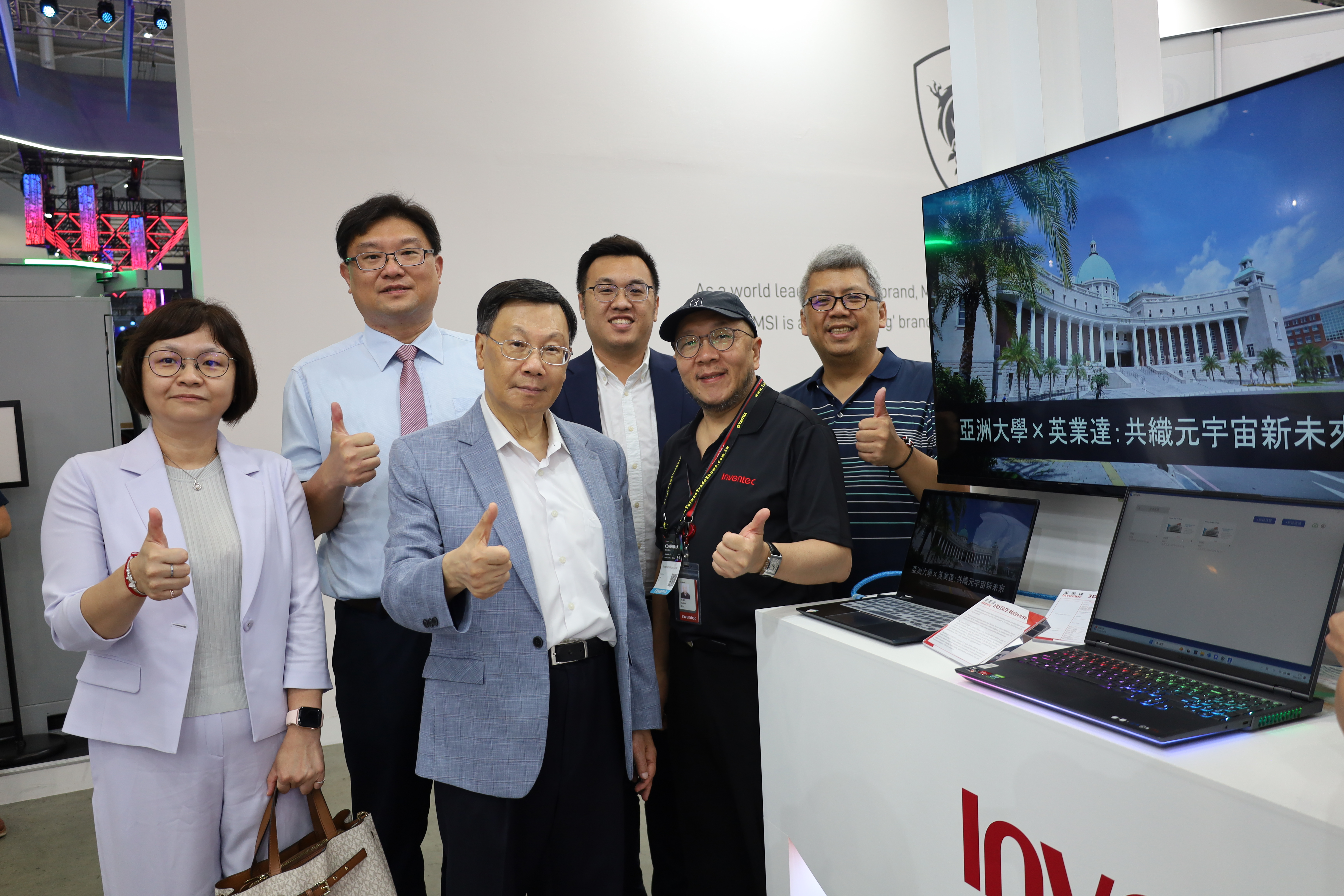 圖為英業達在Computex展位，展示與亞大合作的「元宇宙校園」，亞大校長蔡進發(左3)與亞大師長、英業達元宇宙技術處Senior Manager林昭良(右2)等合影。