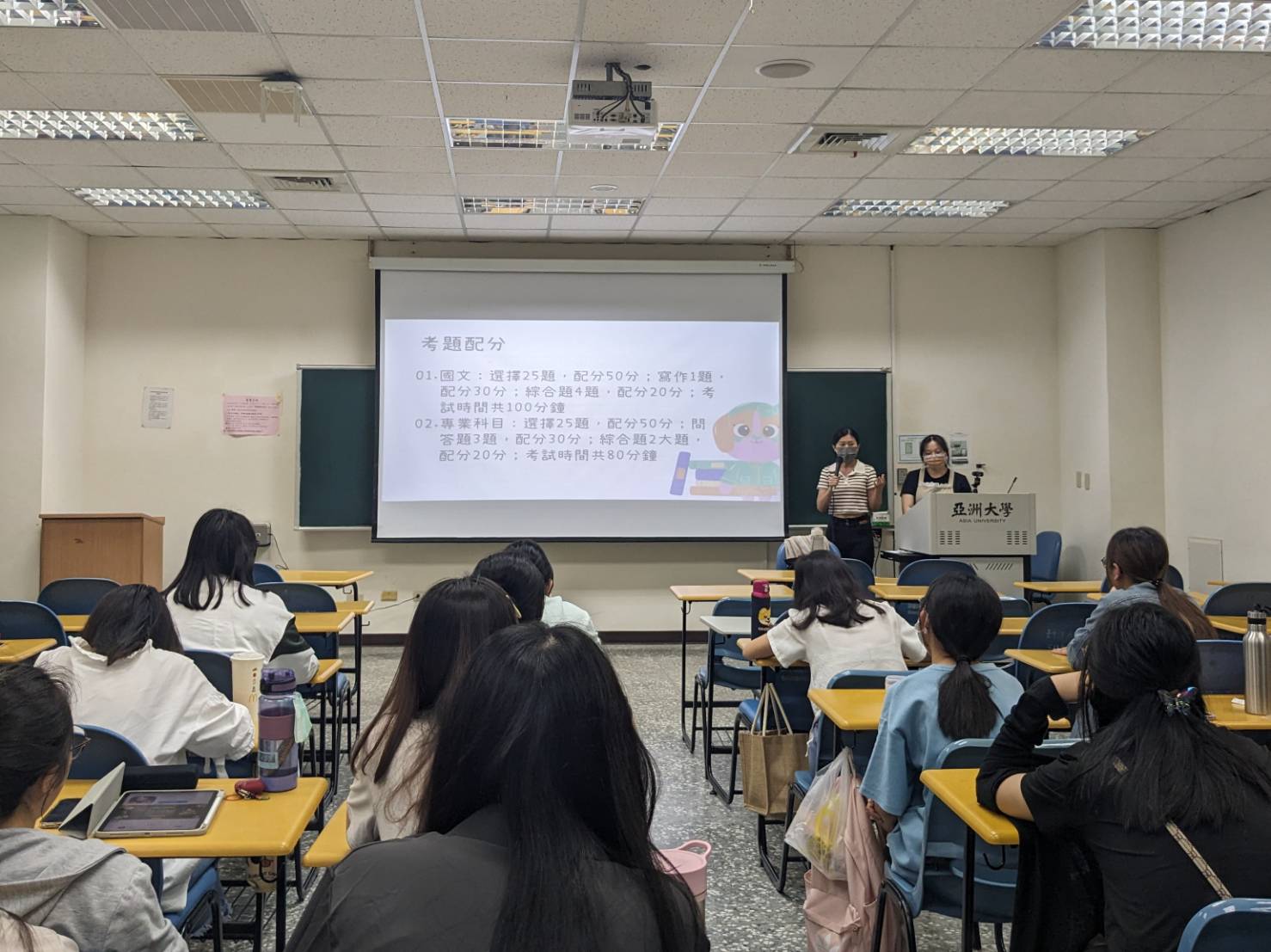 圖為亞大幼教系校友洪郁淳(站立者左)、胡瑜元(站立者右),返回系上分享國考準備經驗。