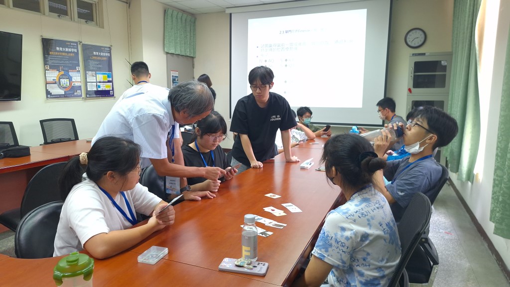 圖為亞大副校長曾憲雄(站立者左),在「運算思維與橋牌」課程中,教導同學橋牌規則。