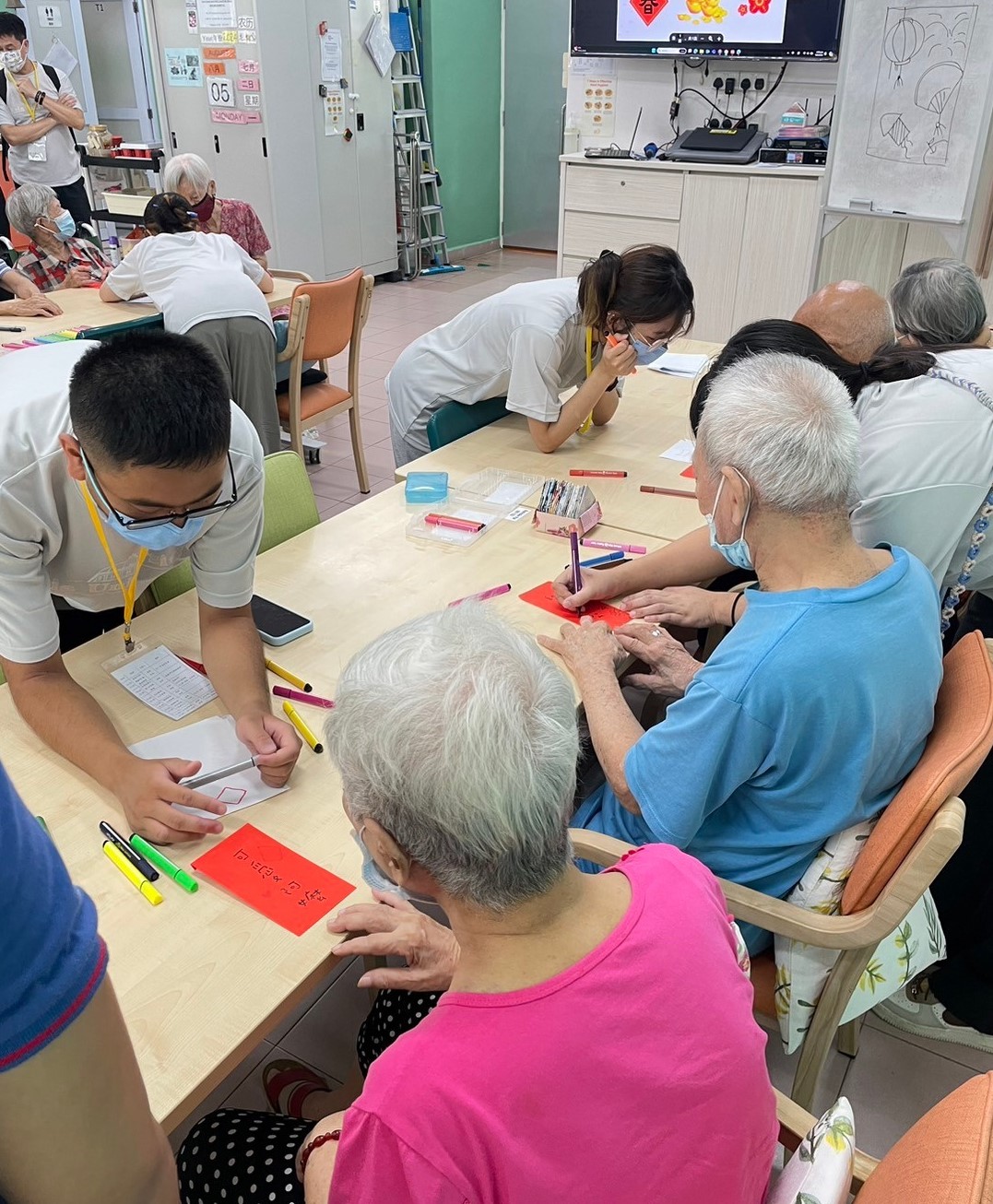 圖為亞大志工團同學,以手作教案在新加坡「Care Corner日照中心」,與長者互動。