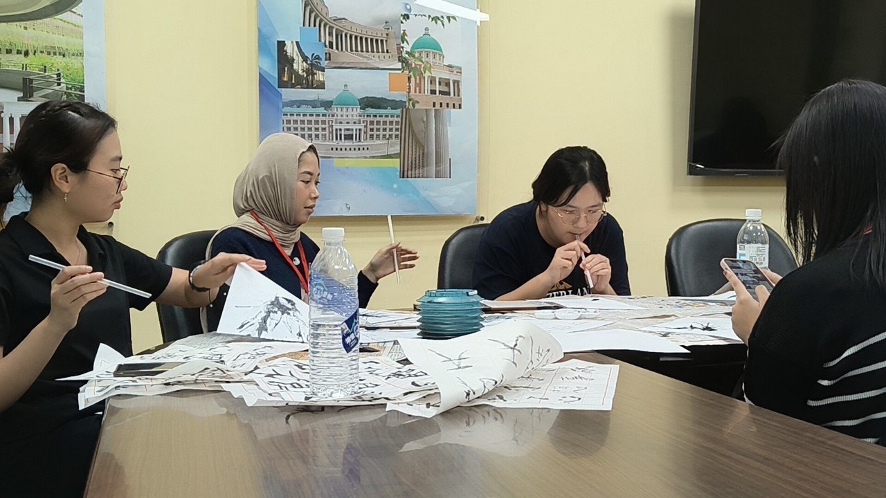 圖為國際生在課程中,學習書法和吹墨。