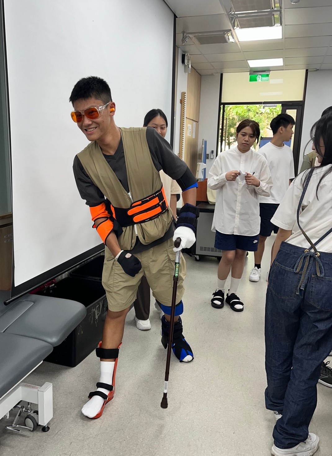 圖為亞大物治系新生穿上模擬套組,實際體驗患者在日常生活步行的挑戰。