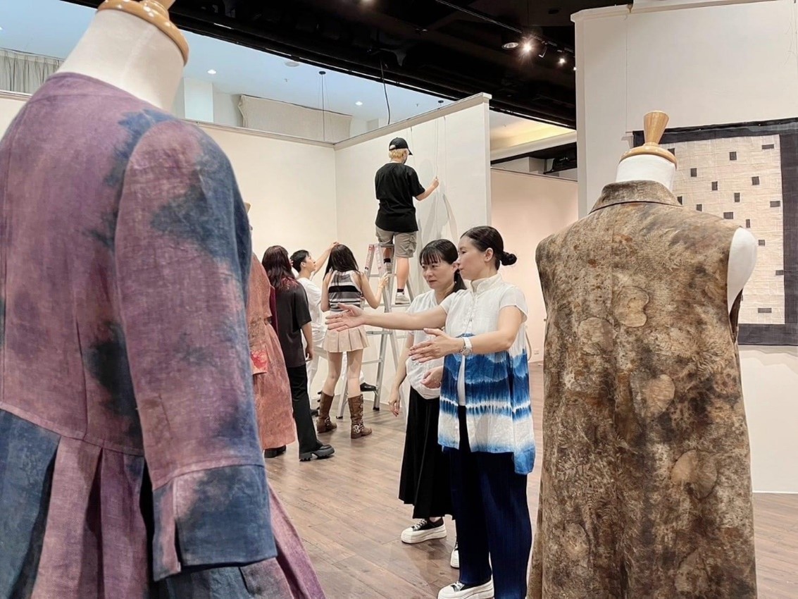 圖為亞大時尚系主任林青玫(右),指導同學進行展場空間定位及調整。