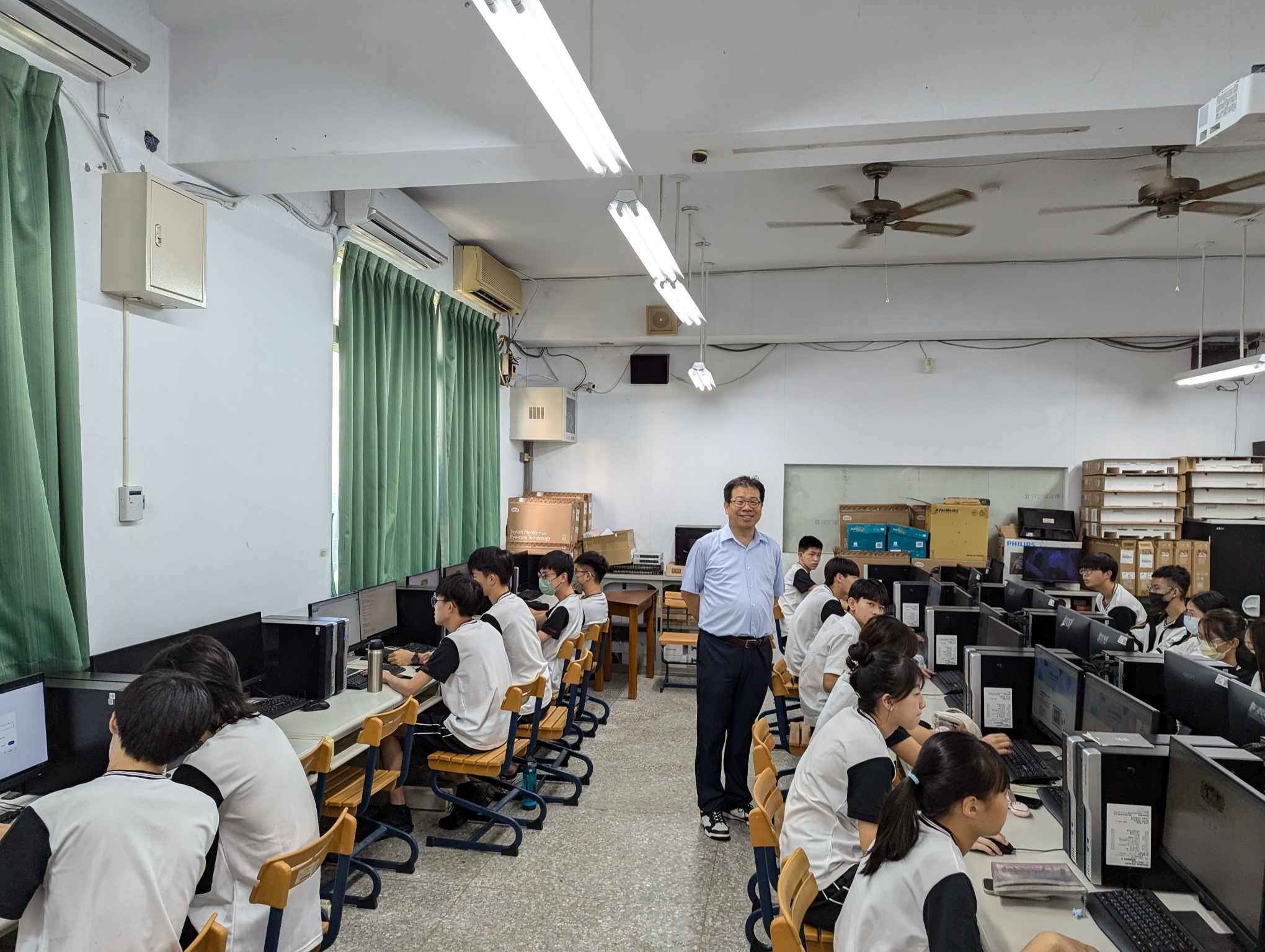 亞大針對夥伴高中提供微學程課程,圖為亞大資工系主任朱學亭(站立者),為豐原高中同學上資訊科技微學程課程。