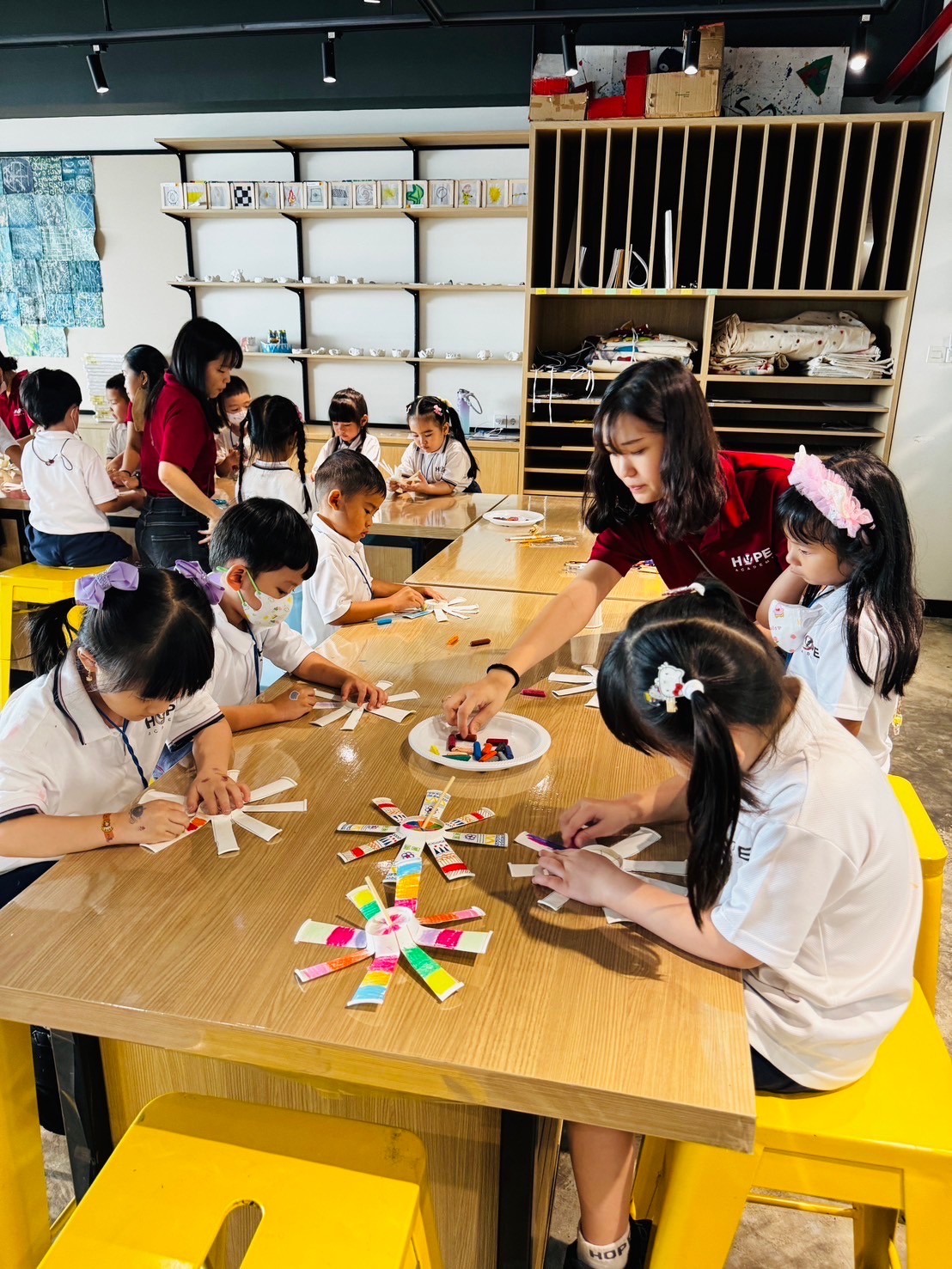 圖為亞大幼教系同學,在台灣傳統文化之旅課程活動中,教導小朋友製作紙杯陀螺。