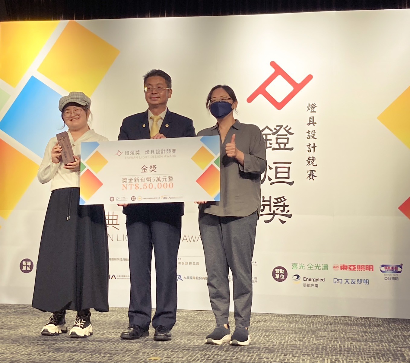 圖為亞大商設系同學作品《光竹舞》,獲「2024燈烜獎」金獎,由指導老師柯雅娟(右)、劉千瑜同學(左)代表領獎。