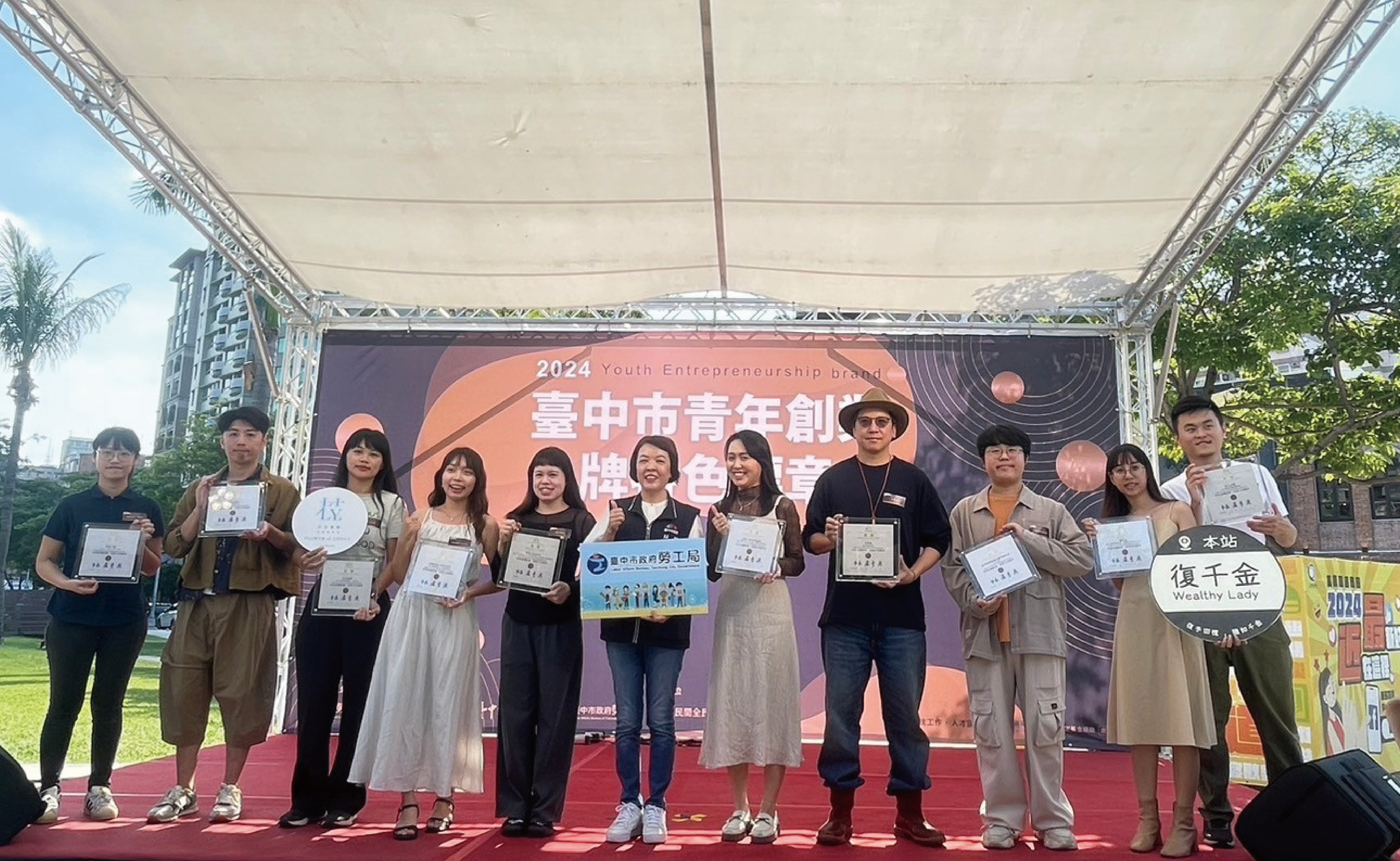 圖為亞大商設系林奕箴同學(右2),以地標木片筆獲文創類「非買不可」標章。