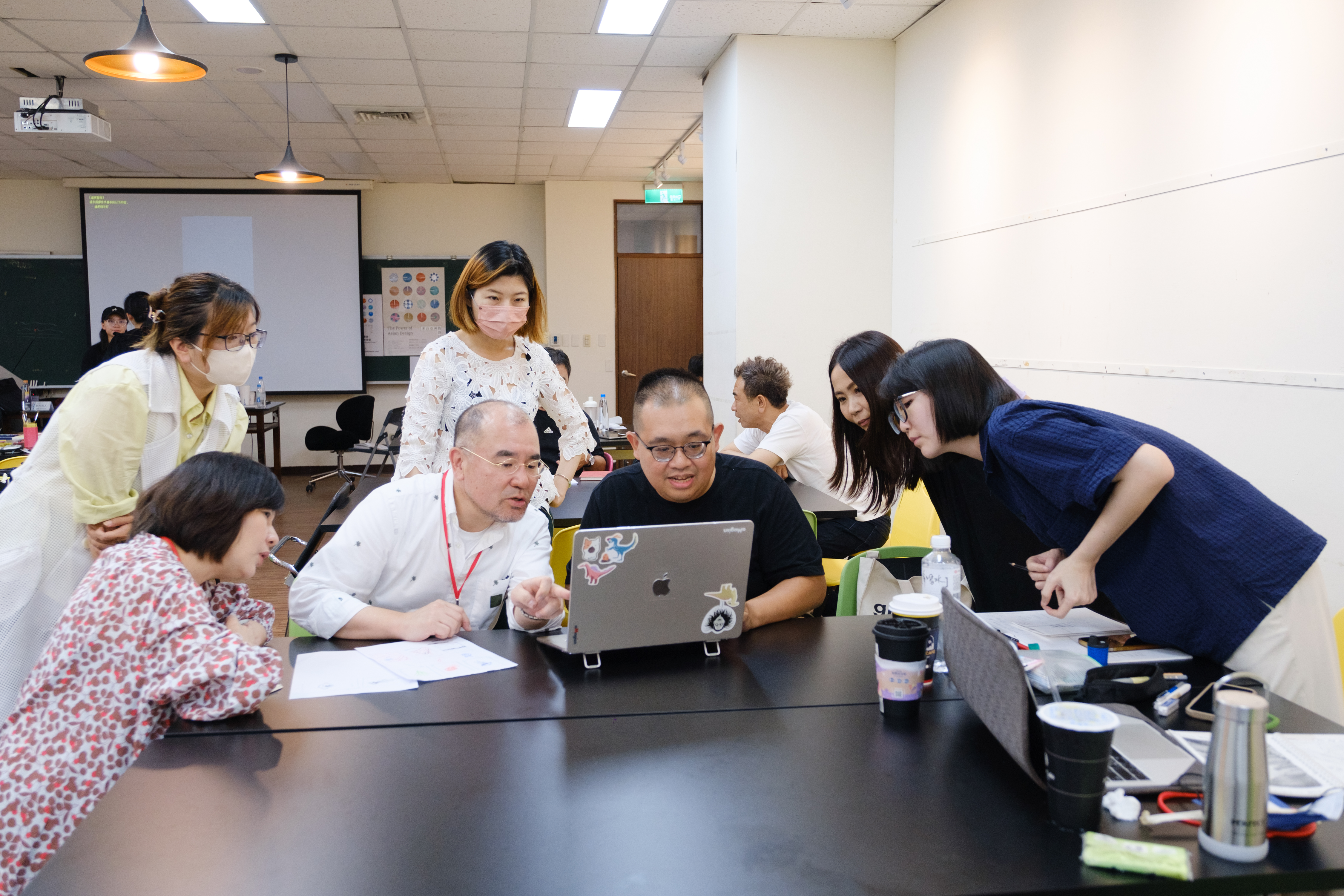 圖為日本設計師新村則人老師(坐者左2),與教師組學員進行創意發想討論。