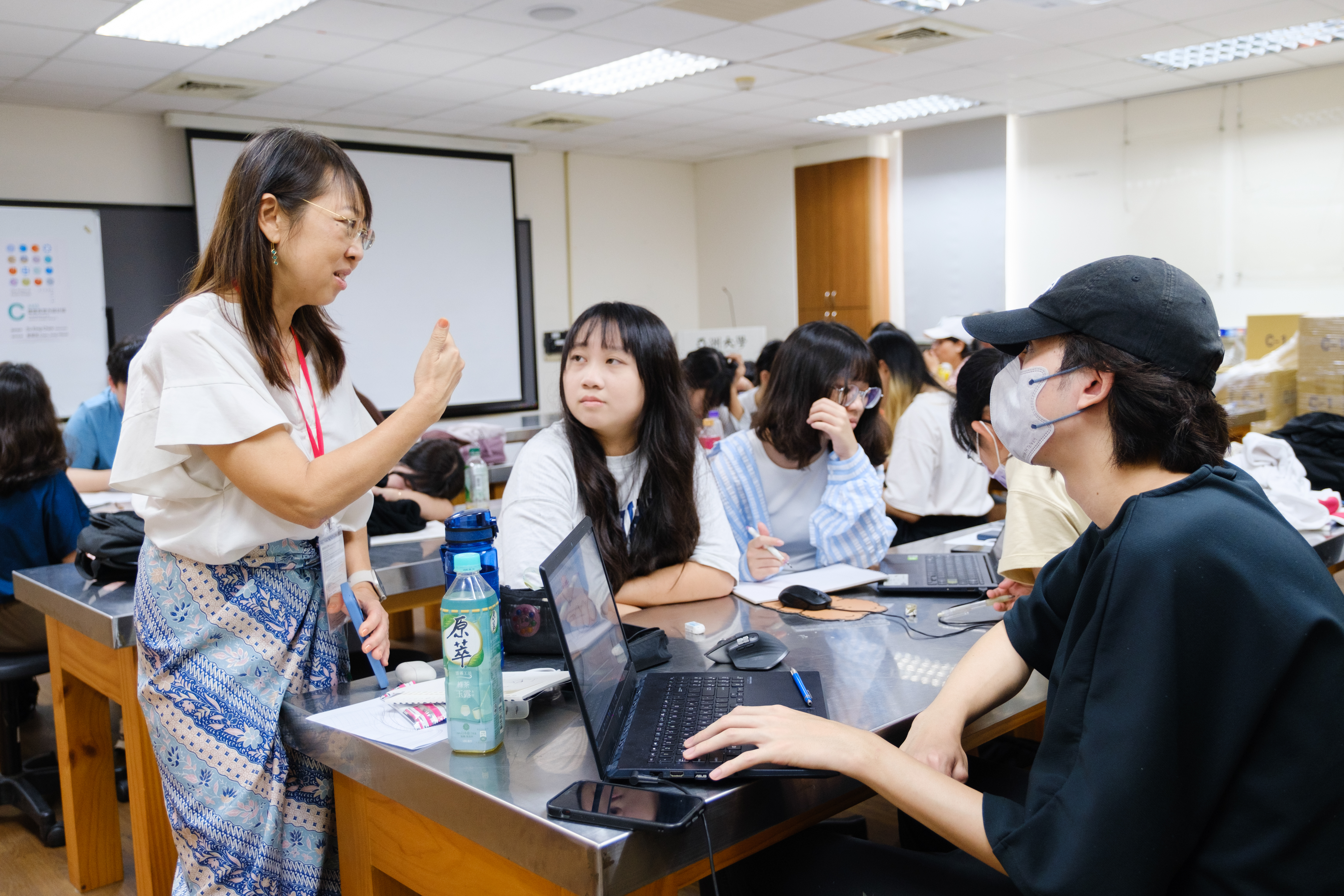 圖為新加坡設計師池舒穎(左),參與學員設計討論。