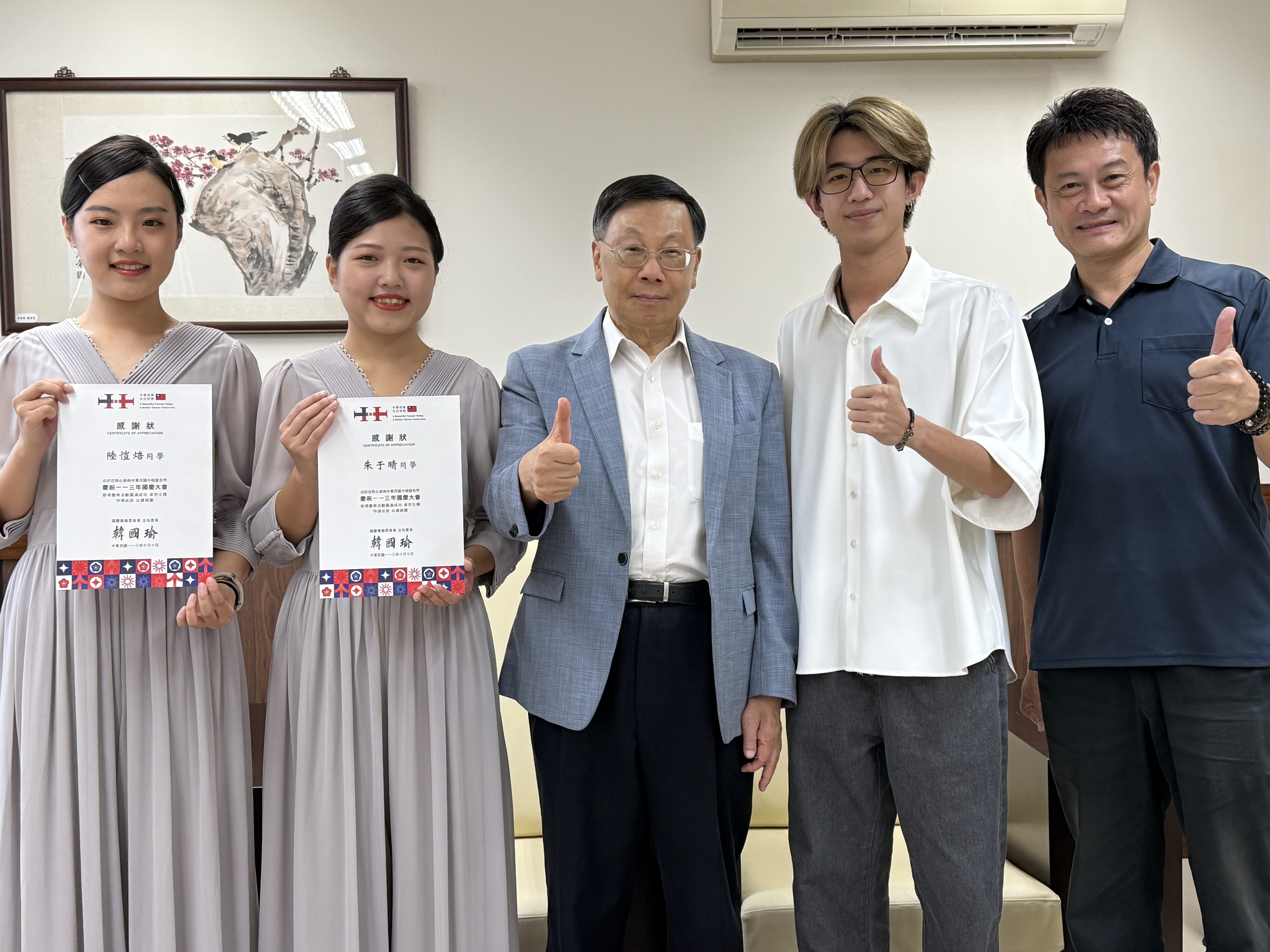 圖為亞大校長蔡進發(中),和副學務長簡信男、擔任國慶大典接待的陸愷焙、朱于晴同學等合影。
