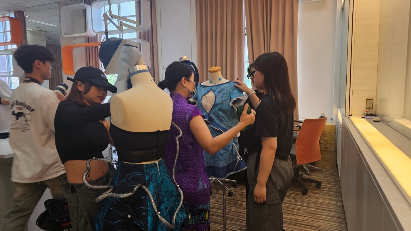 圖為亞大時尚系主任林青玫(右2),指導同學服裝設計與製作。