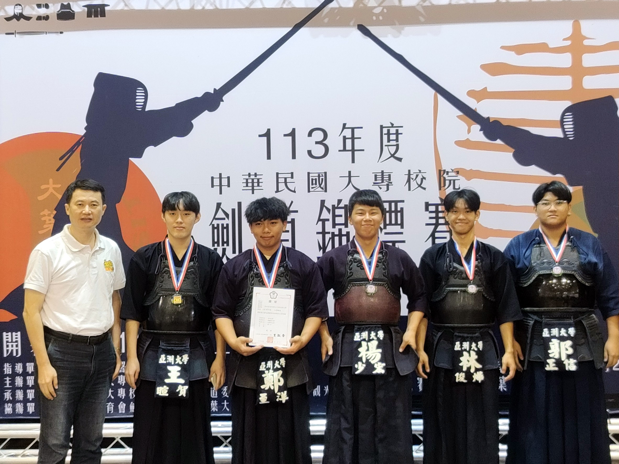 圖為亞大劍道校隊(由左而右)指導教練、商設系主任龍希文,和王暄賀、鄭至洋、楊少宏、林俊燁同學,在比賽會場合影。