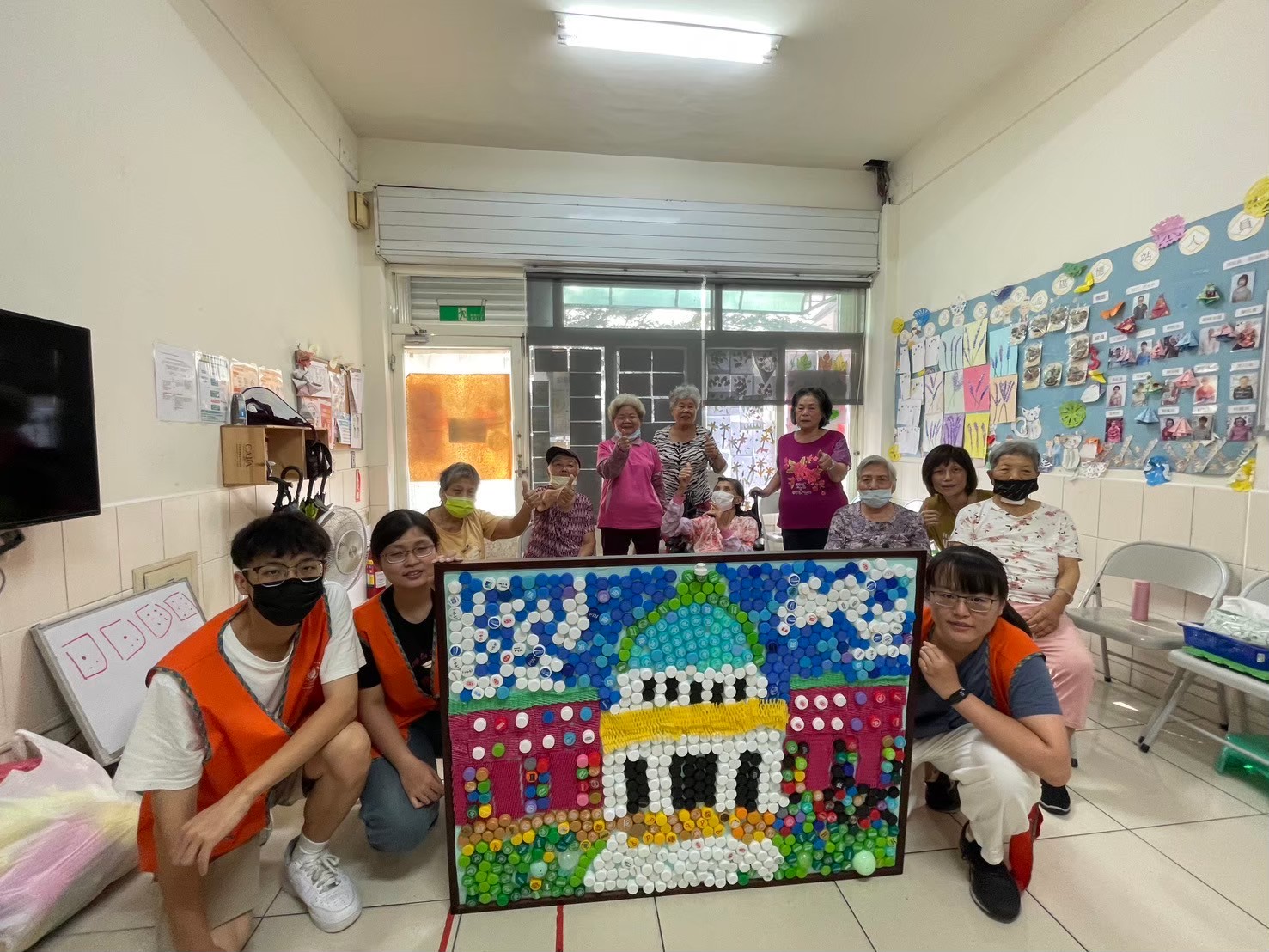 圖為亞大護理系同學,創意發想利用廢棄瓶蓋,帶領霧峰北柳憶站長輩完成「藝塑永續」藝術輔療作品。