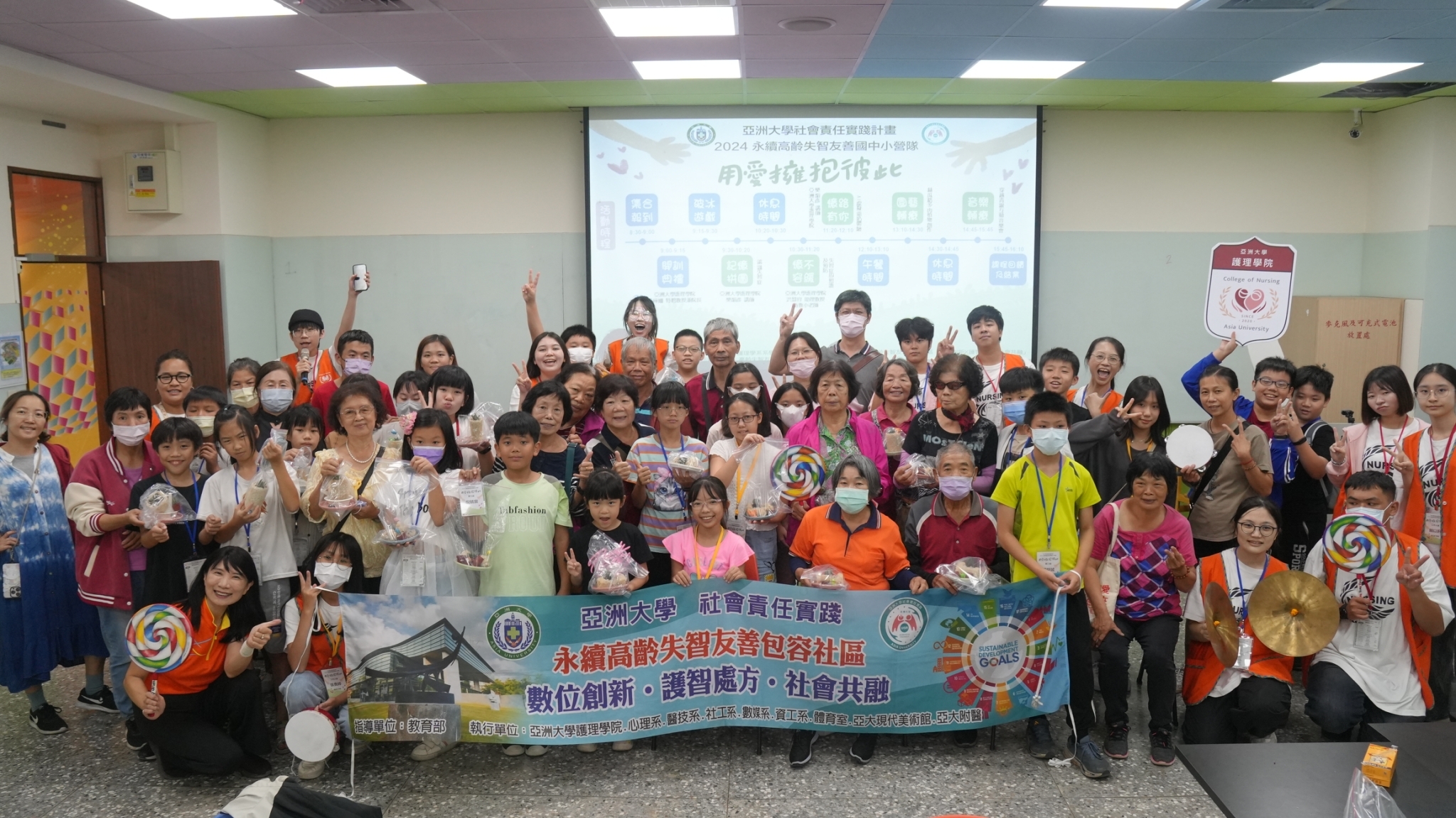 圖為亞大護理學院舉辦失智友善營隊活動,參與學員和家長,與台中市霧峰六股社區發展協會長輩、護理系師生合影。