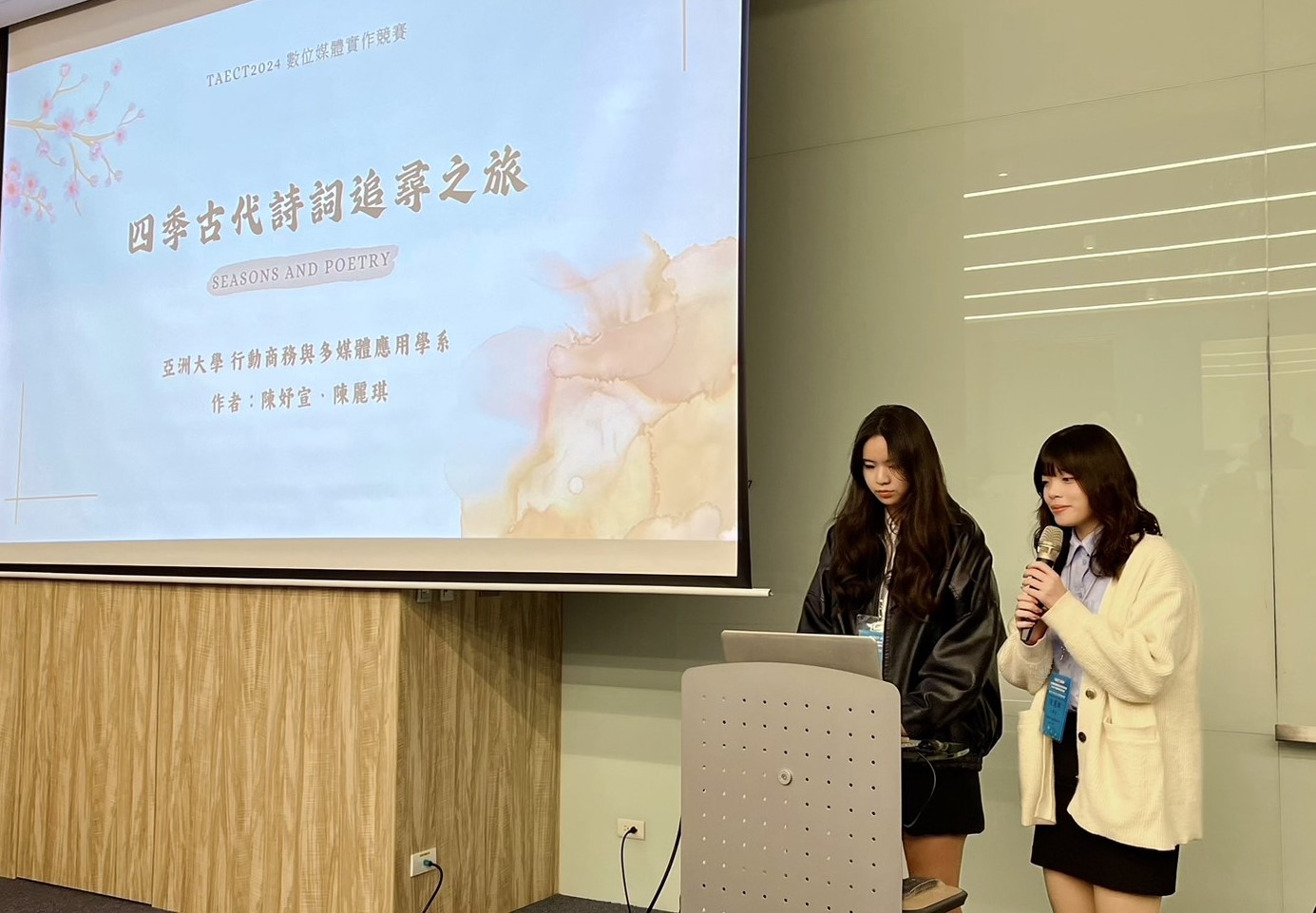 圖為亞大商應系陳妤宣(左)、陳麗琪(右)同學,在「2024台灣教育傳播暨科技學會年會」數位媒體競賽決賽中,進行簡報與作品展示。