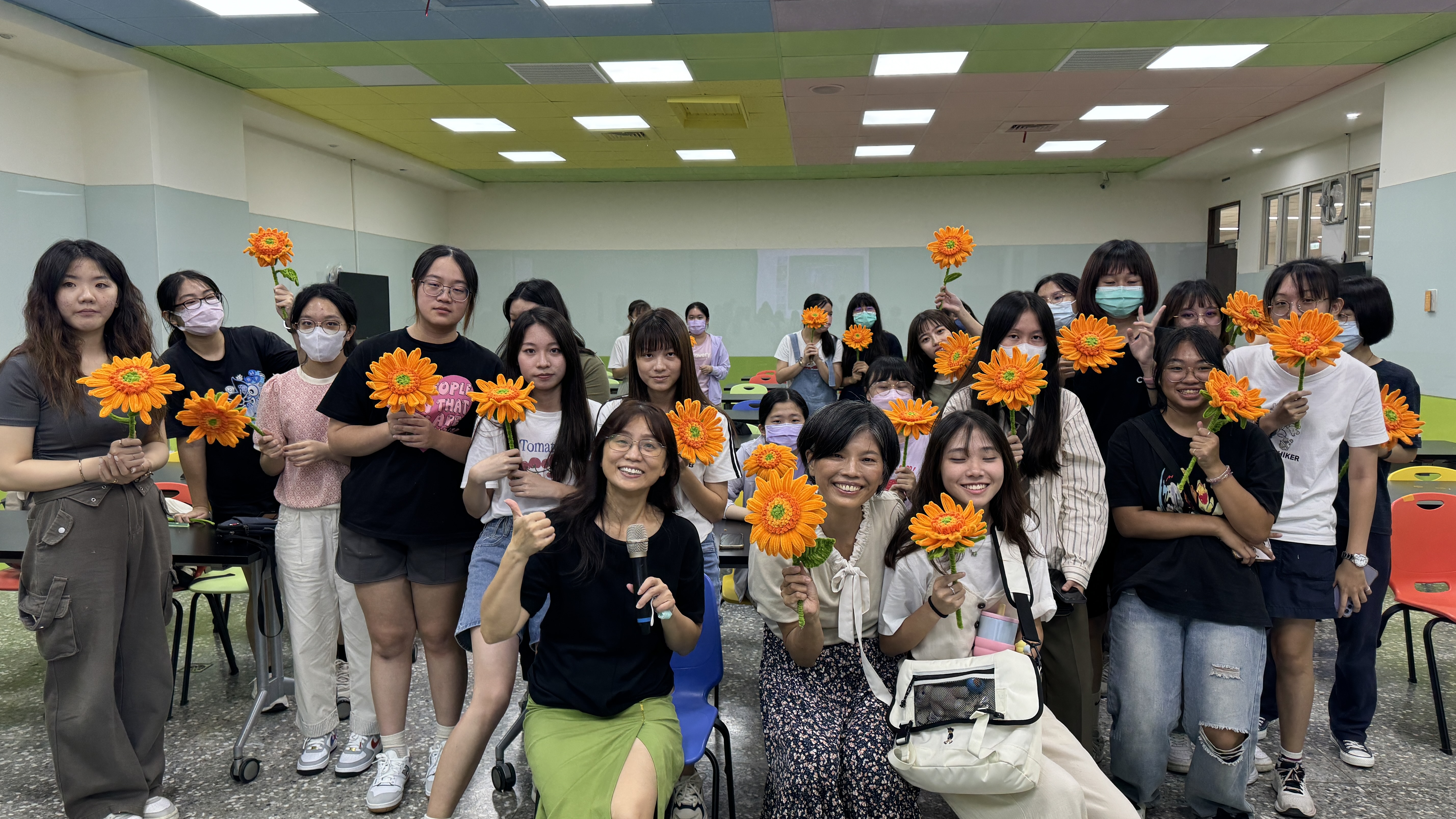 圖為亞大同學以扭扭棒製作向日葵,師生合影。