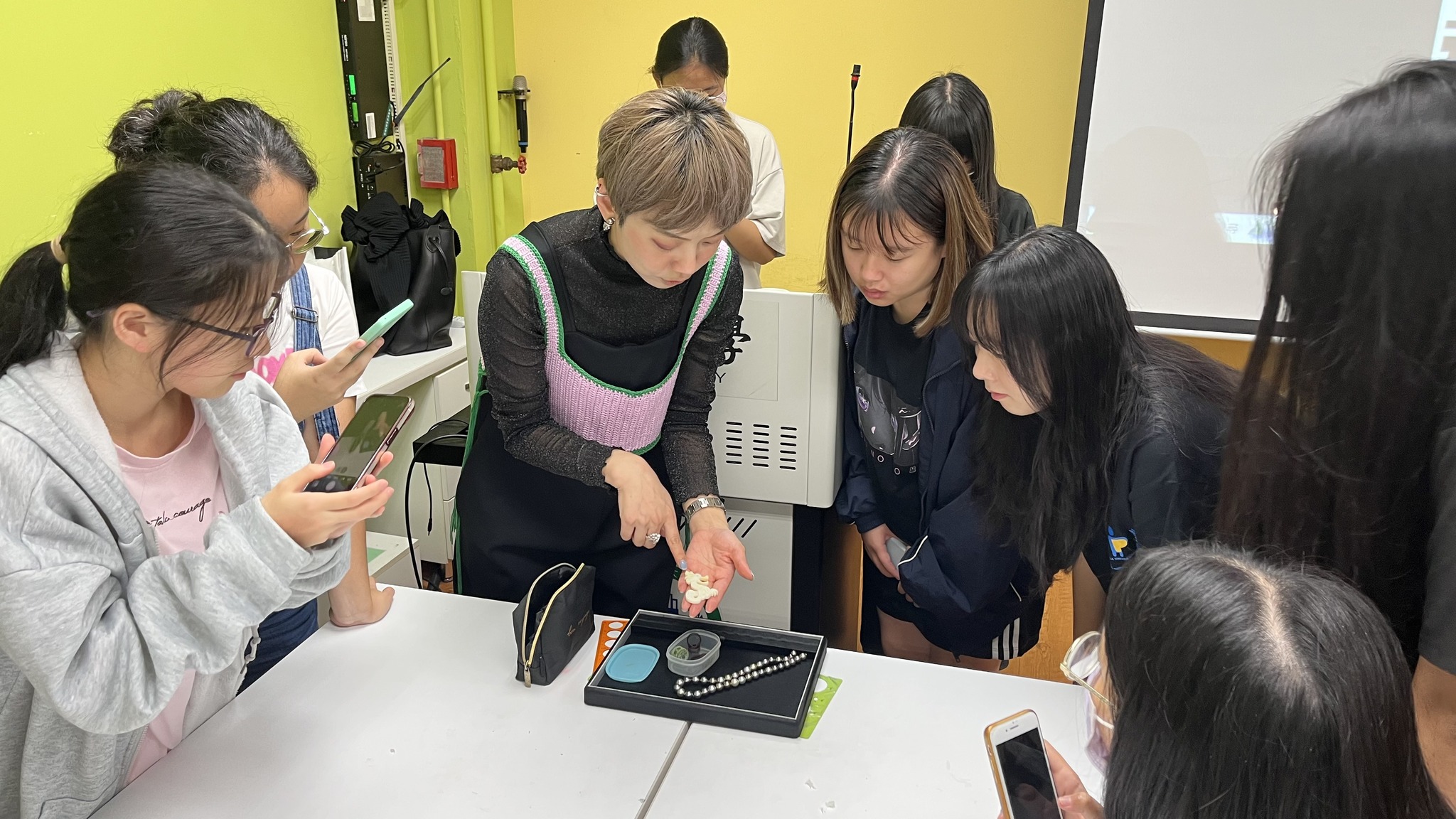 圖為在探索珠寶課程中,Jamie老師(左3),指導同學創作戒指。