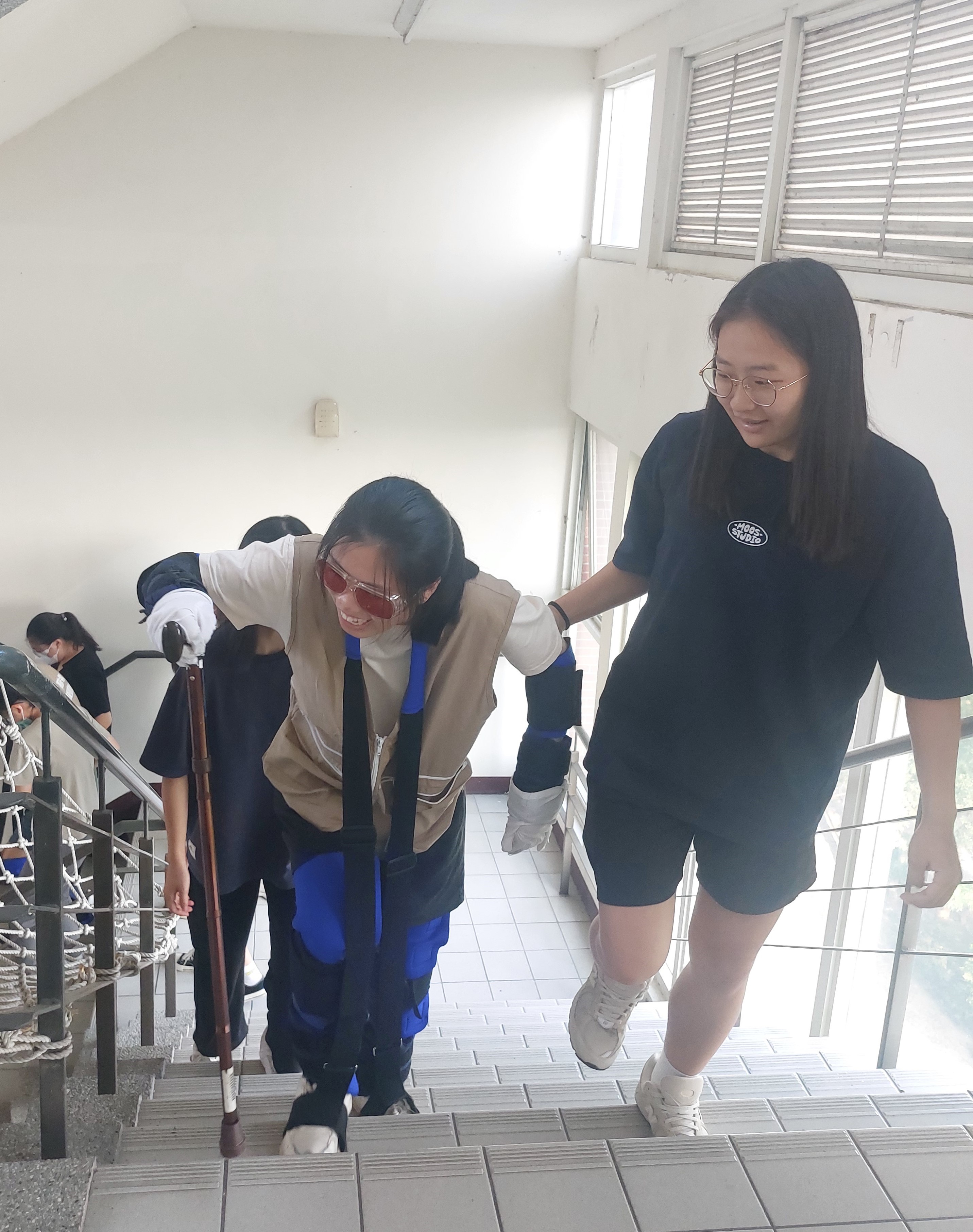 圖為亞大健管系同學,體驗長者腿部退化爬樓梯。