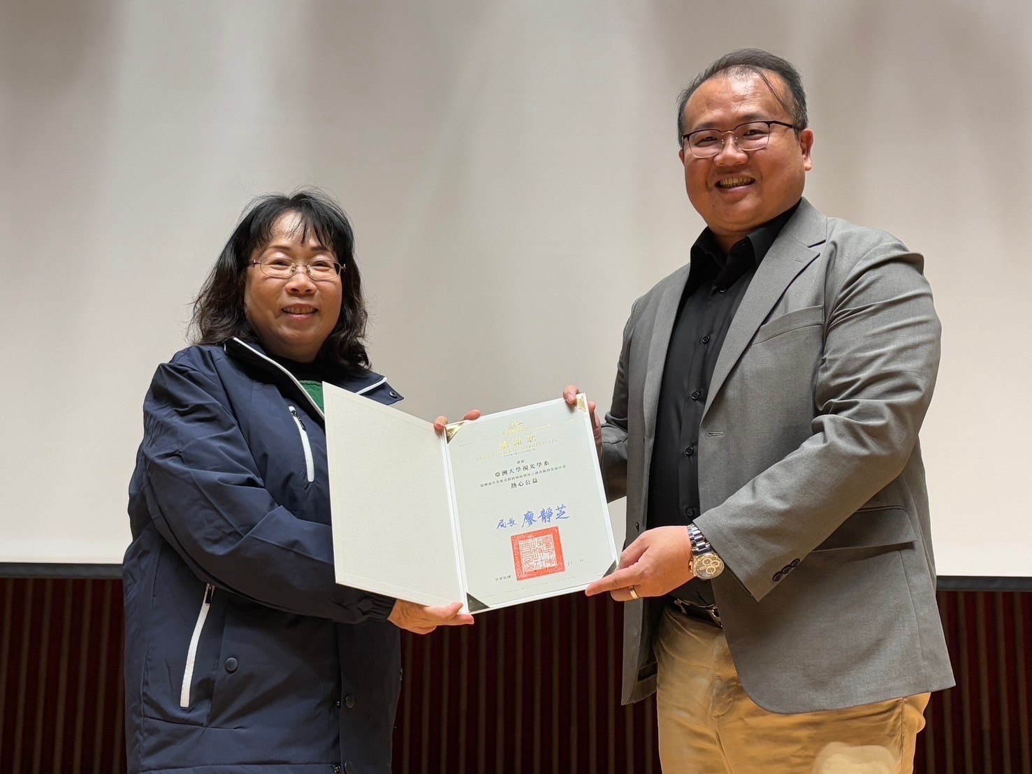 圖為台中市社會局長廖靜芝(左),頒發感謝狀給亞大視光系主任曾榮凱(右)。