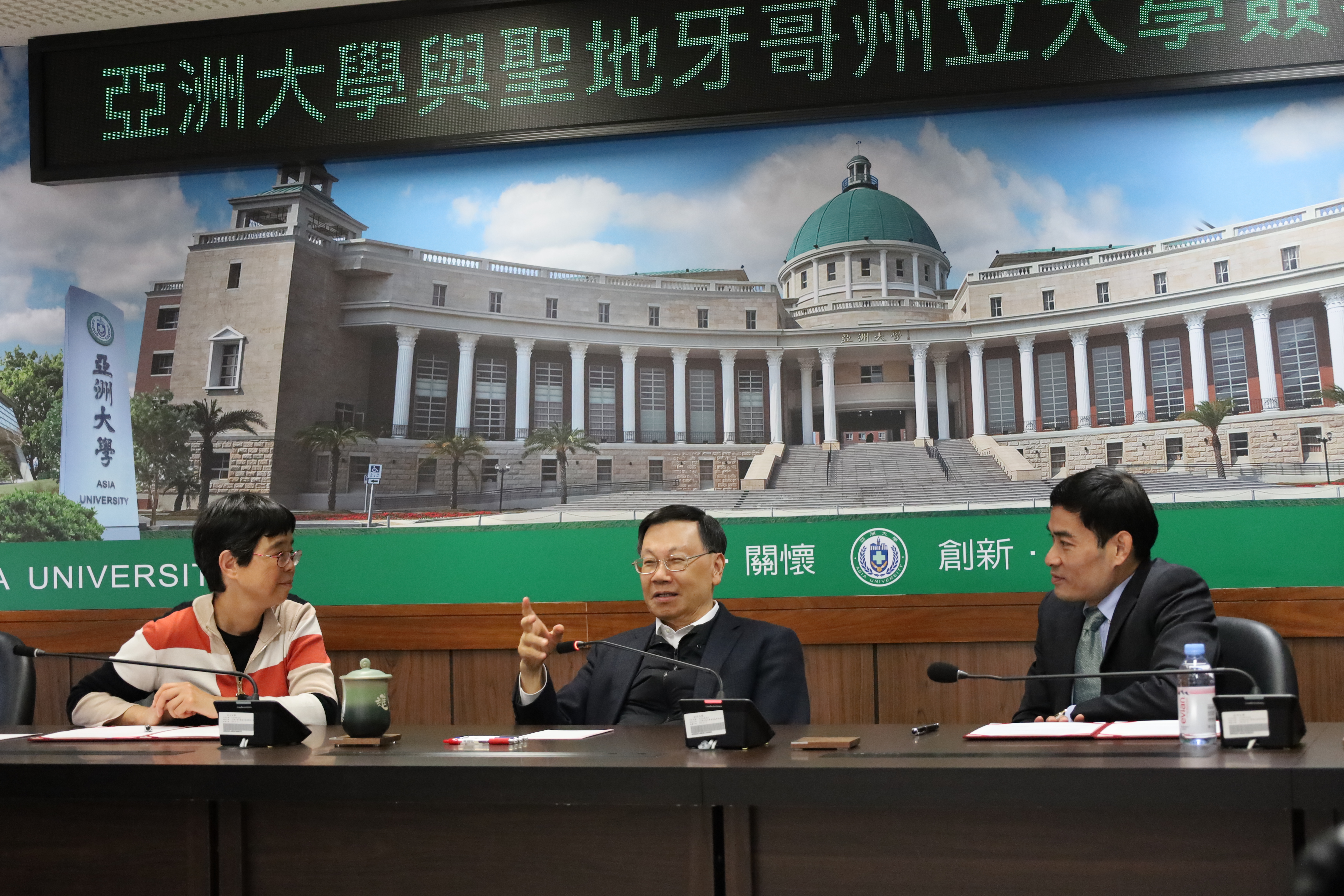圖為亞大校長蔡進發(中)、資電學院長許慶賢(右)，向美國聖地牙哥州立大學電腦科學系主任任尚苹(左)，介紹亞大在半導體的發展。
