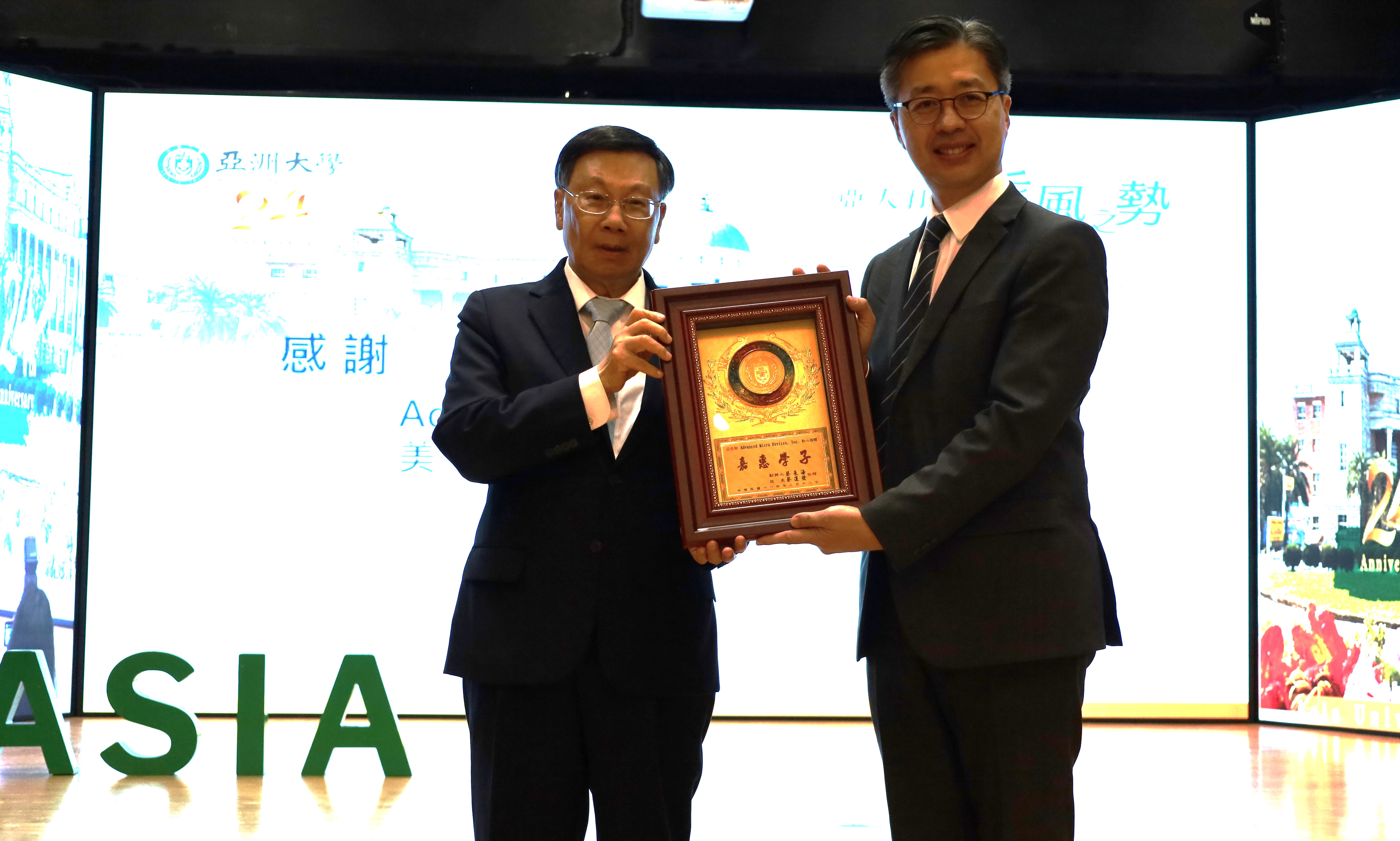 亞大校長蔡進發(左),在亞大24周年校慶頒發感謝狀,感謝美商超微半導體AMD公司提供運算資源,由AMD資深業務協理黃偉喬(右)代表接受。