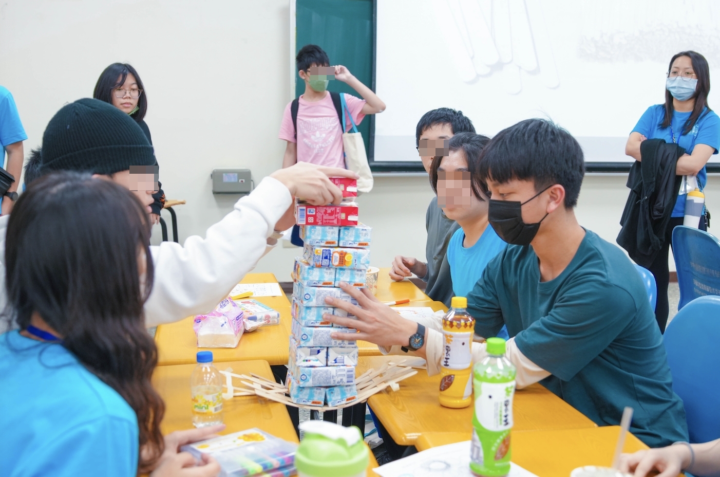 在「創意設計」課程中，學員發揮創意，用冰棒棍搭建能承重飲料的吊橋。