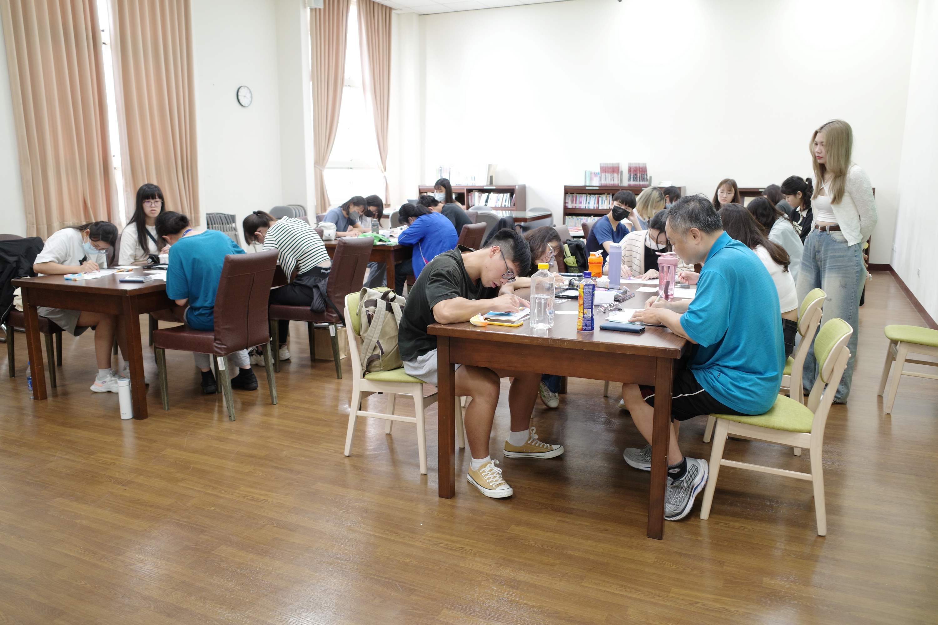 文創作者「熊老闆」(站立者)，指導同學以油粉彩作畫。