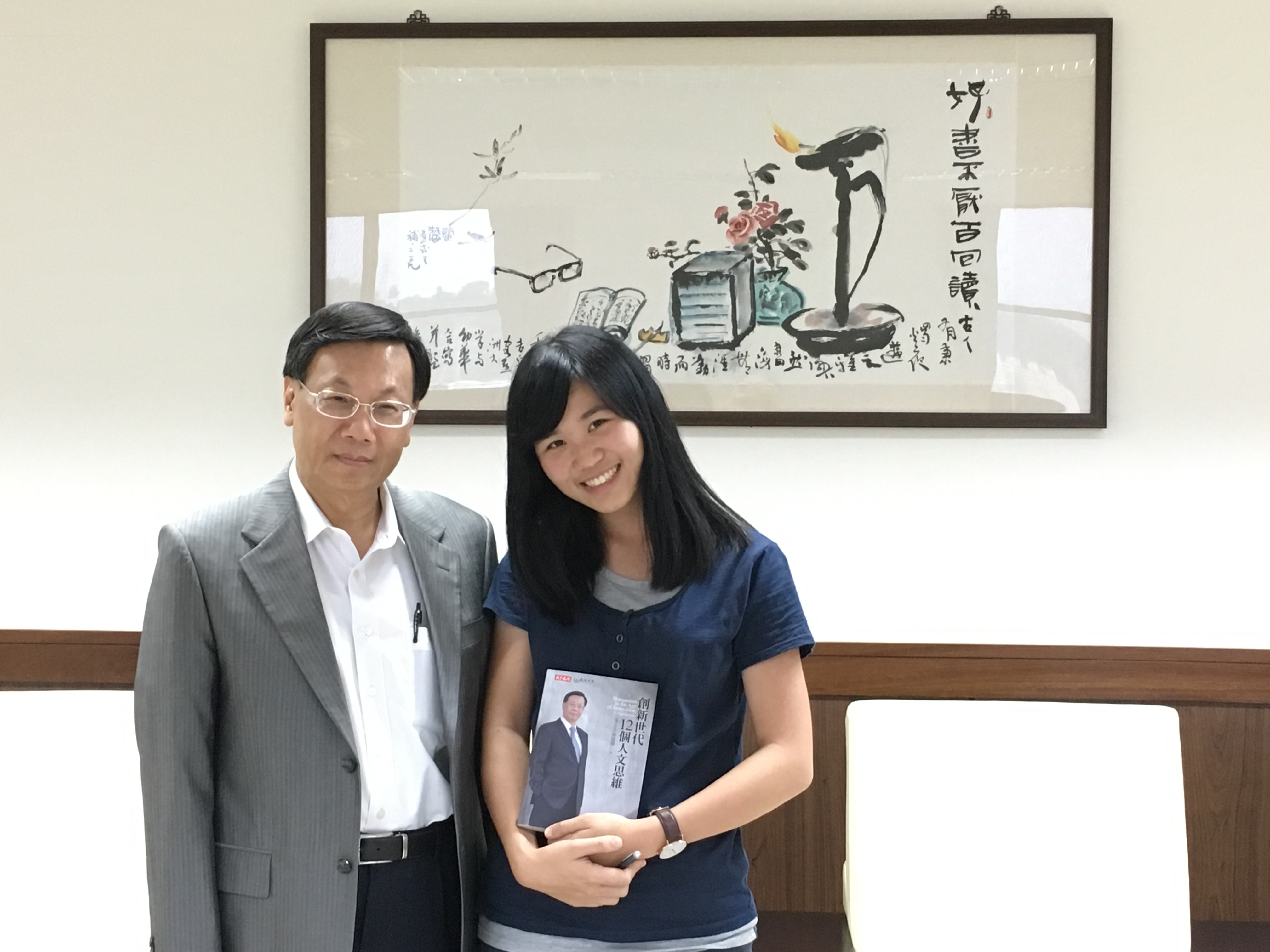 亞大校長蔡進發(左),贈送他所著的《創新世代12個人文思維》,給當時就讀亞大聽語系的黃宥瑄校友(右),以書中所寫給年輕人的12種人文思維,鼓勵她勇敢逐夢。