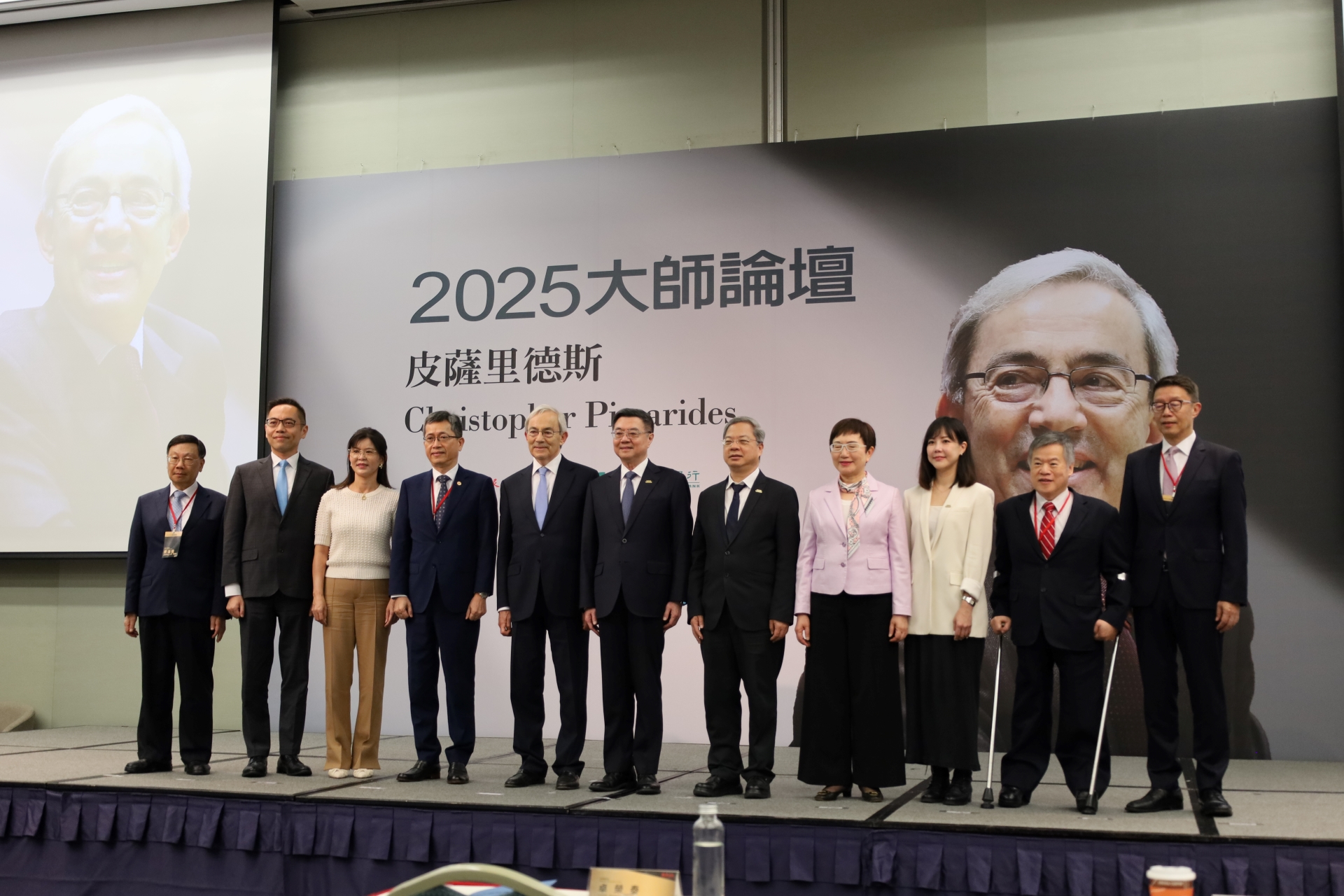 「2025大師論壇」，亞大校長蔡進發（左一）、諾貝爾大師皮薩里德斯教授（左五）、行政院長卓榮泰等與會代表合影。